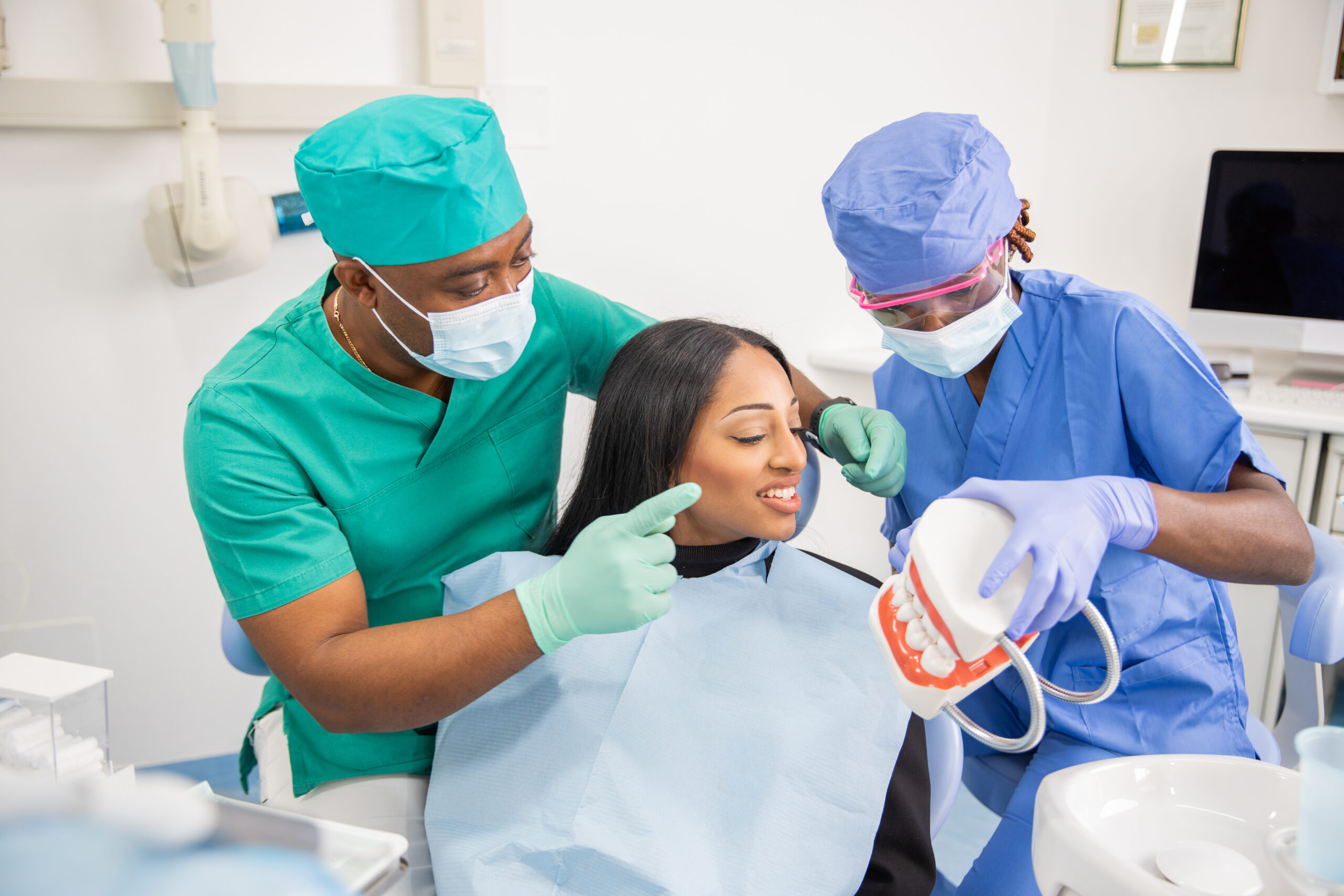 A dentist gives a consultation to a patient and with his assistant they explain the teeth