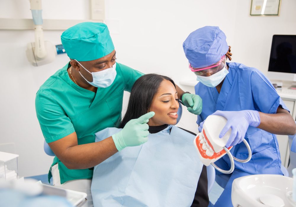 A dentist gives a consultation to a patient and with his assistant they explain the teeth